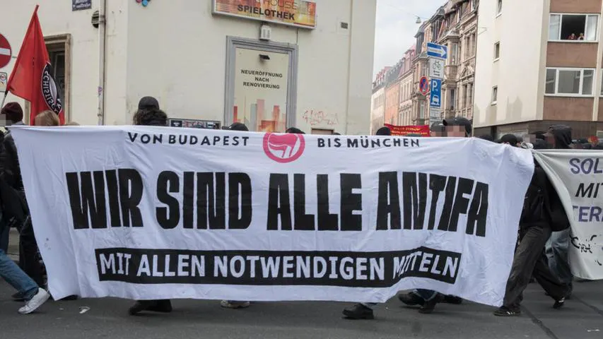 weißes Transpi mit schwarzer Schrift "Wir sind alle Antifa - mit allen notwendigen Mitteln", Demo in Nürnberg anlässlich des Urteils gegen Hanna