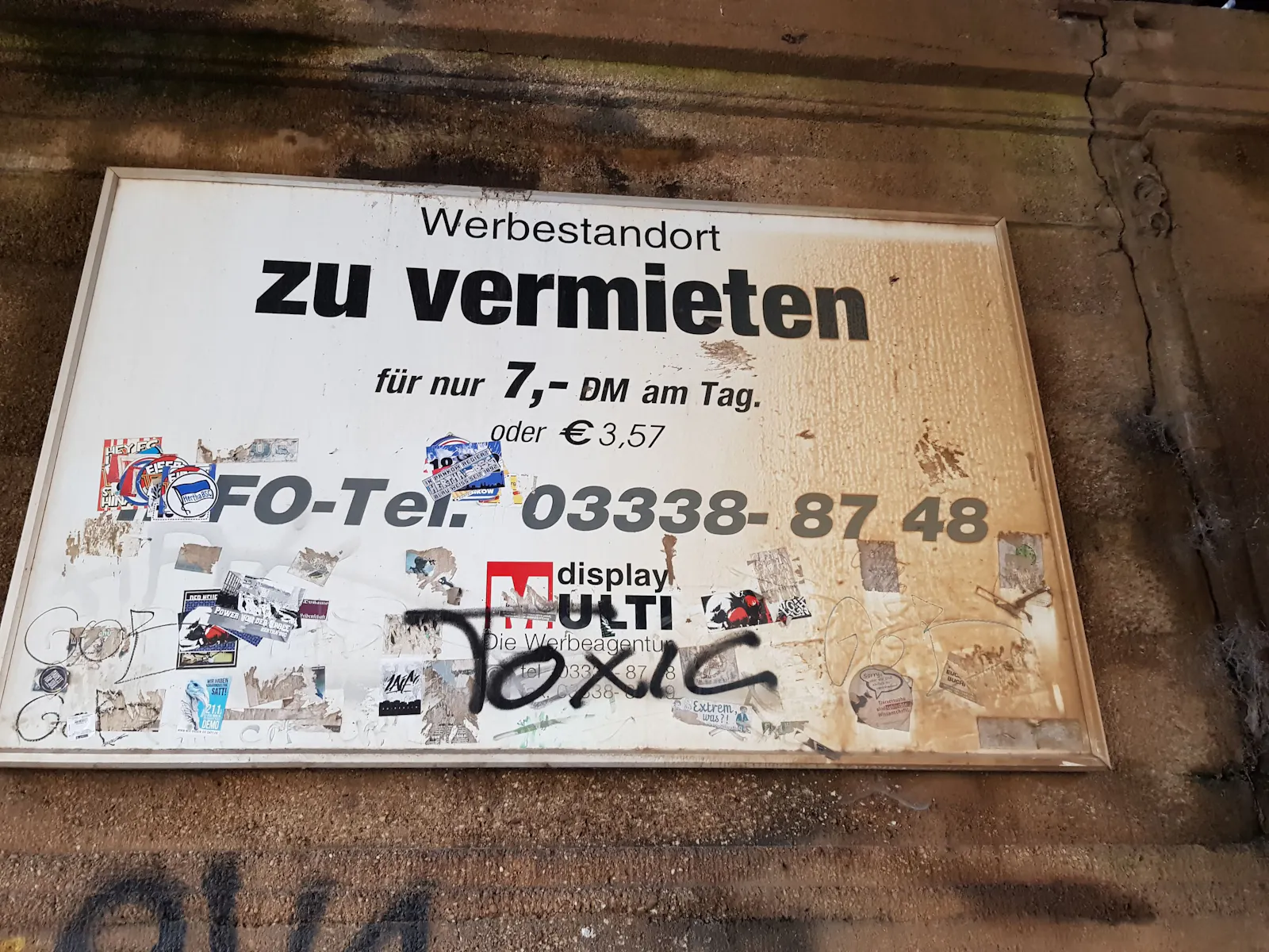 Uralte, verwitterte Außenwerbungs-Außenwerbung, bei der der Preis noch in D-Mark angegeben ist