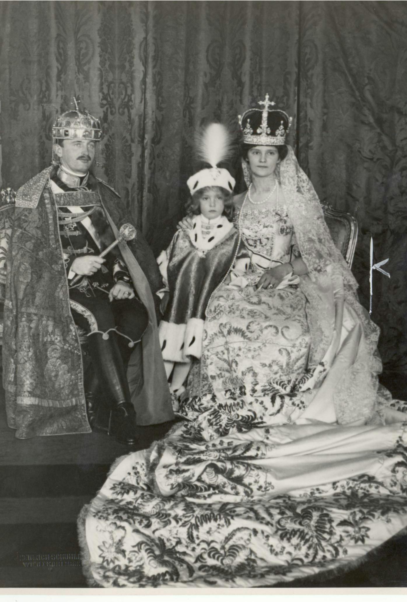 Das Bild zeigt Kaiser Karl I. zusammen mit seiner Frau Zita und seinem Sohn Otto. Die Aufnahme ist schwarz-weiß und stammt aus dem Jahr 1916.