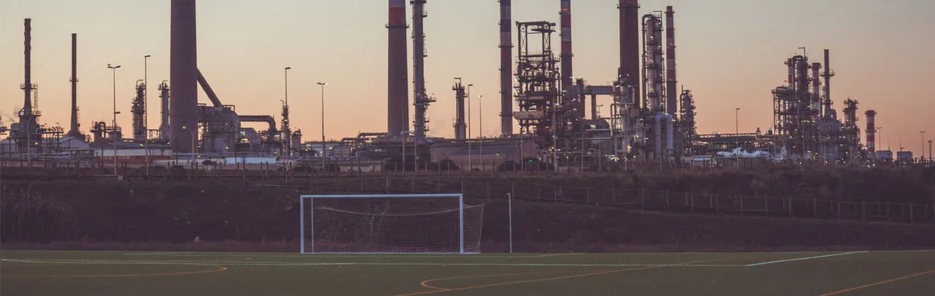 Leeres Fußballfeld vor industriellen Strukturen
