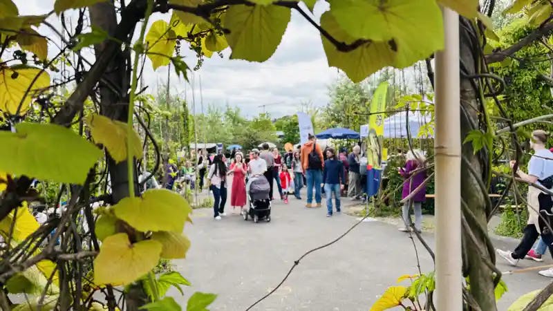 [Asphaltsprenger-Festival in Hamburg: Menschen hinter einer grünen Blätterwand]