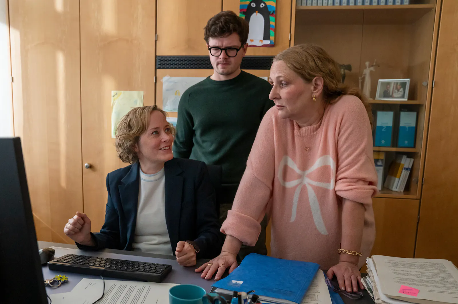 "Ein ganz großes Ding": Im Büro der Bürgermeisterin: Kristina Lurz (Silke Bodenbender) sitzt an ihrem Schreibtisch und blickt lächelnd zu Mechthild Börne (Inga Dietrich) auf. Diese stützt sich auf dem Tisch ab und blickt mit hochgezogenen Augenbrauen Kristina Lurz an. Hinter den Frauen steht Lasse (Komparse) und beobachte die beiden aufmerksam.