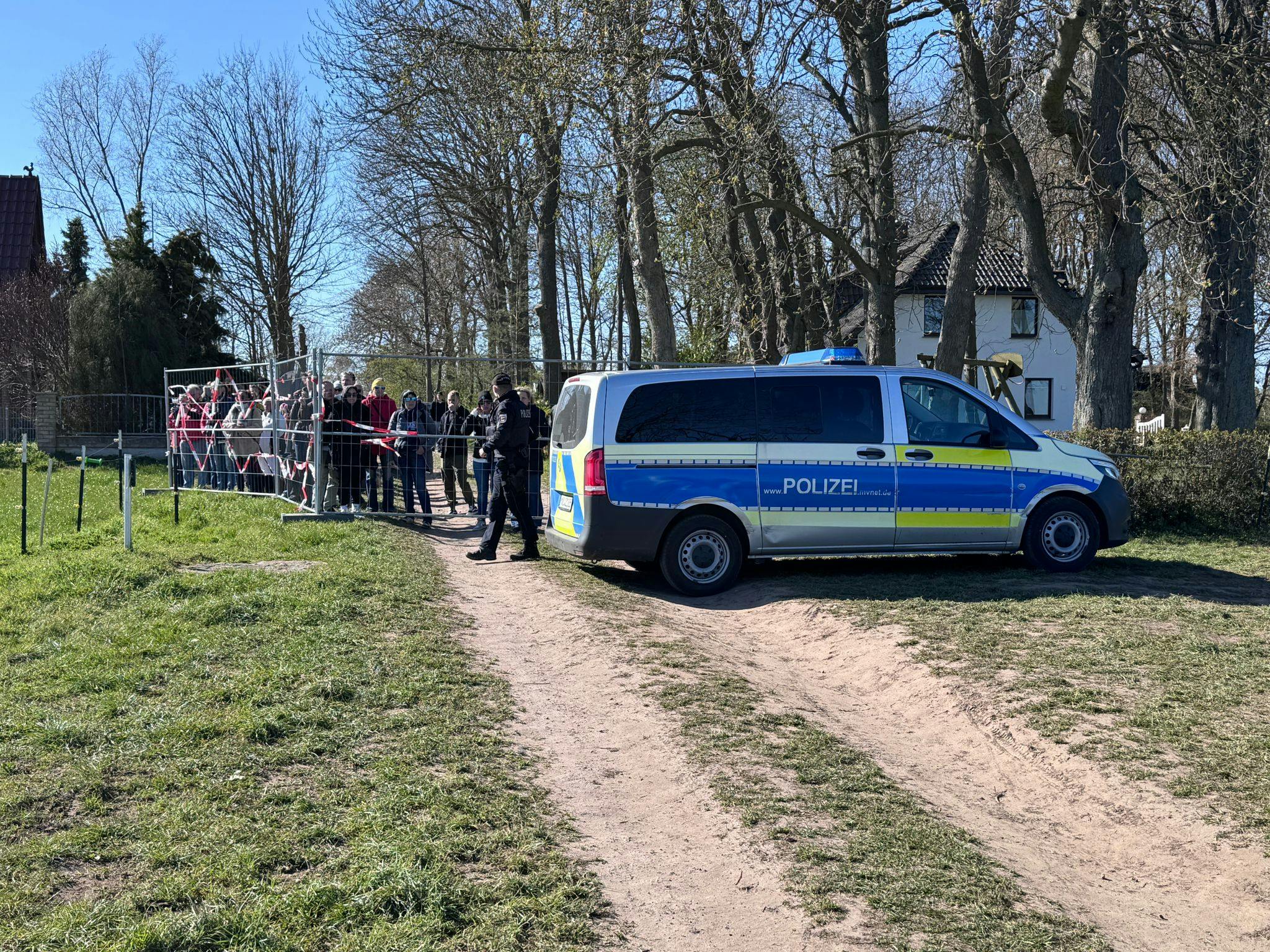 Mehrere Demonstranten an einer Absperrung am Ufer