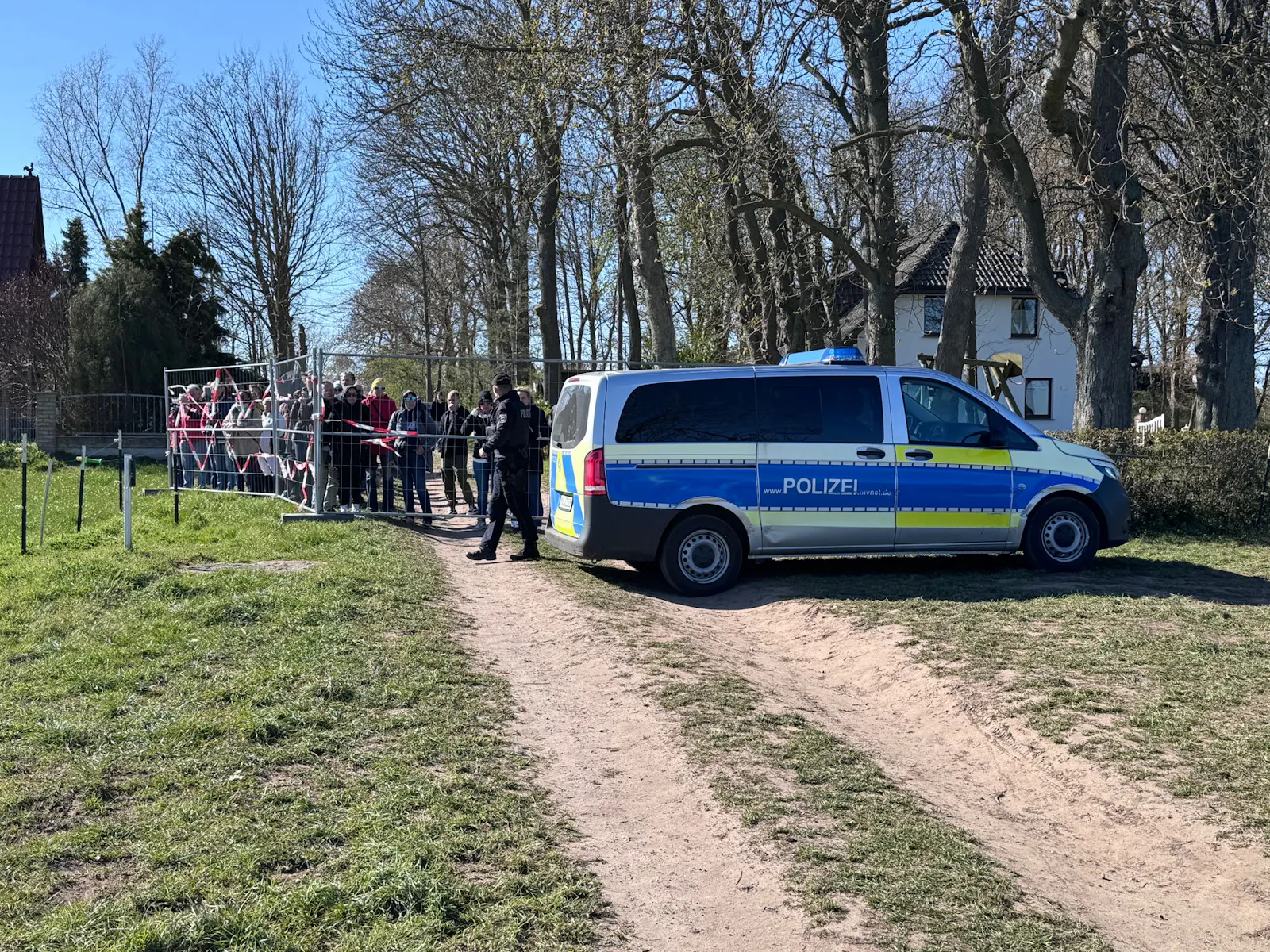Mehrere Demonstranten an einer Absperrung am Ufer