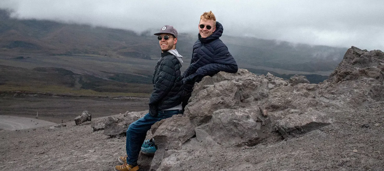 Alex und Lovis sitzen auf einem Stein auf dem Cotopaxi