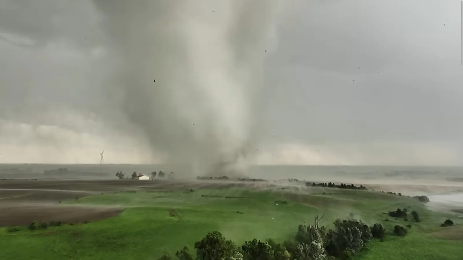 Screenshot 1 aus dem beschriebenen Video: Die Drohne noch weit von der Windhose entfernt, man sieht die Scheine weiß aufblitzen.