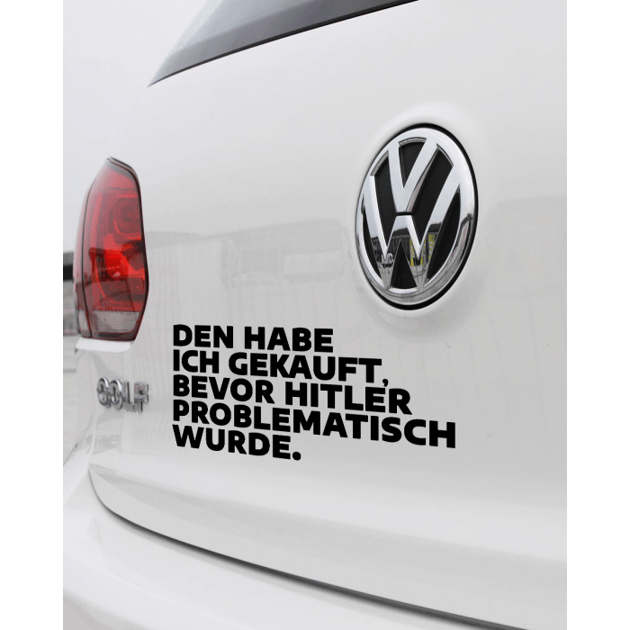 Die Rückseite eines weißen VW. Neben dem VW-Logo klebt ein Sticker mit diesem Text: "Den habe ich gekauft, bevor Hitler problematisch wurde."