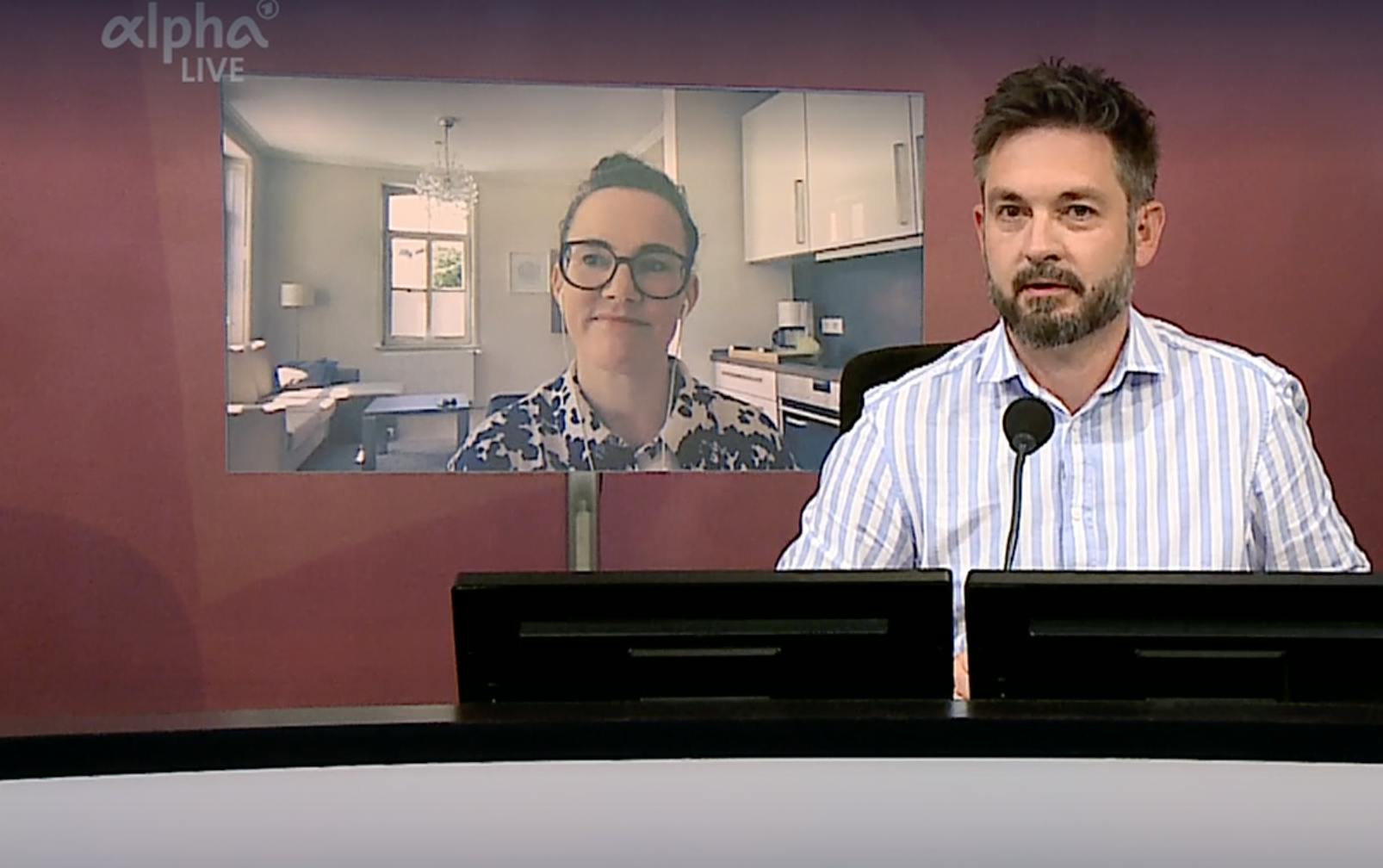 Screenshot des Gespräches im Bayrischen Rundfunk. Ich bin auf einem Monitor eingeblendet, der Moderator sitzt im Studio.