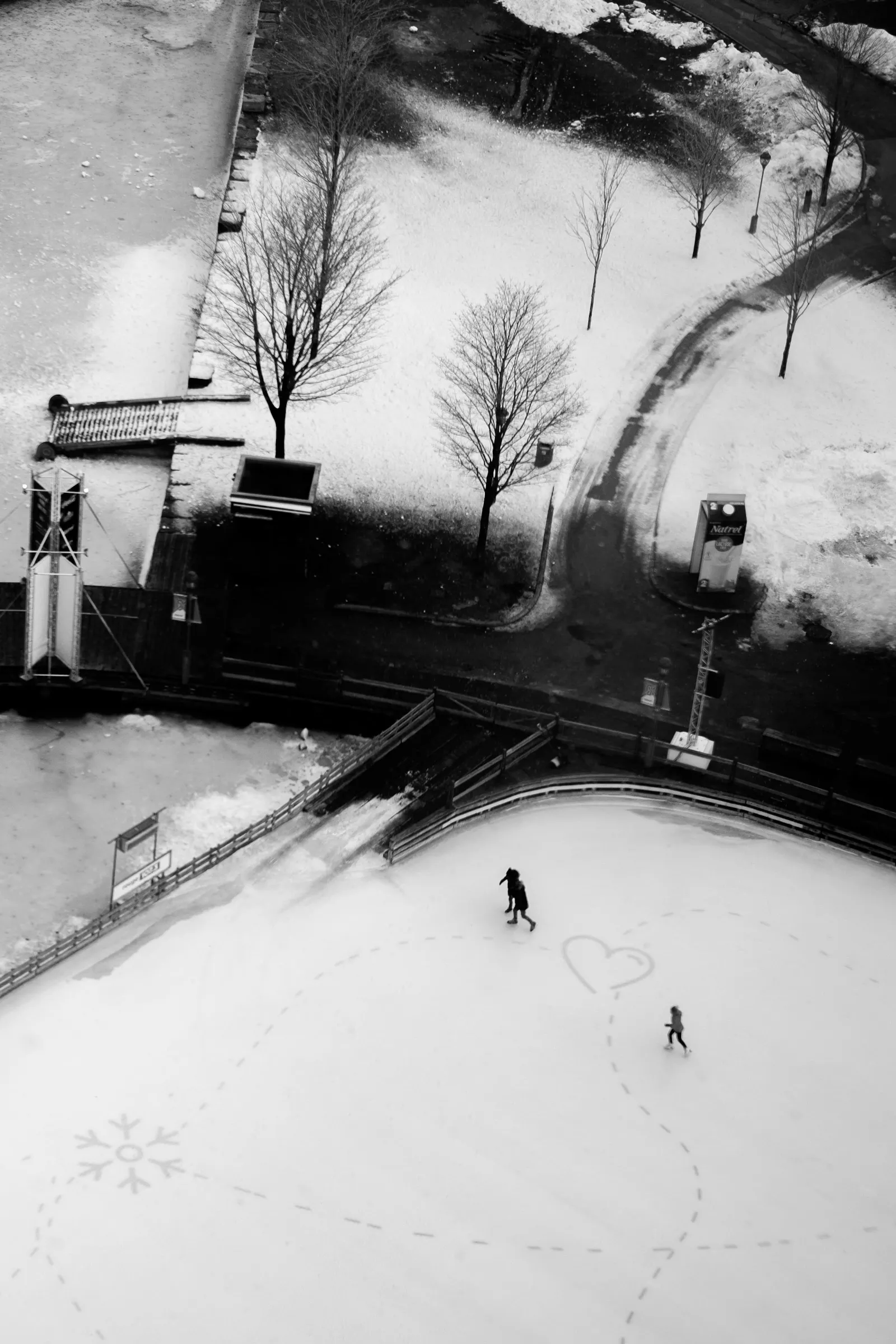 Seen from above, people skate on an ice rink