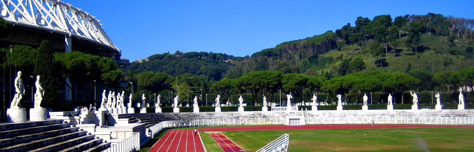 Blick ins Stadio dei Marmi mit antik wirkenden weißen Statuen, die das Stadion umranden