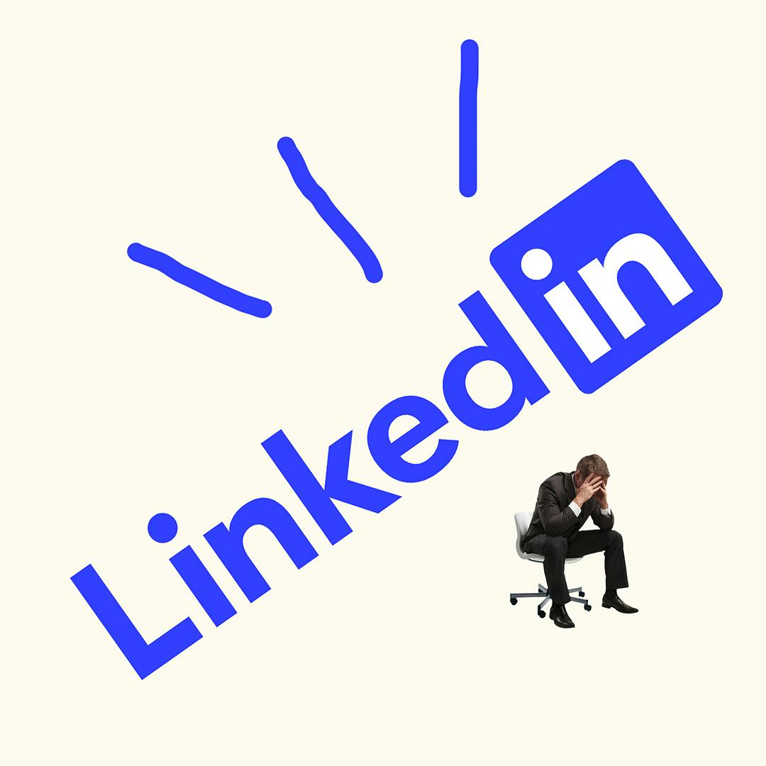 Man sitting on an office chair with head in hands below a large tilted LinkedIn logo with three blue lines above it