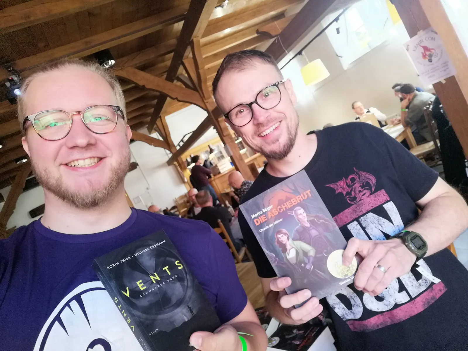 Zwei Autoren halten ihre Bücher in die Kamera