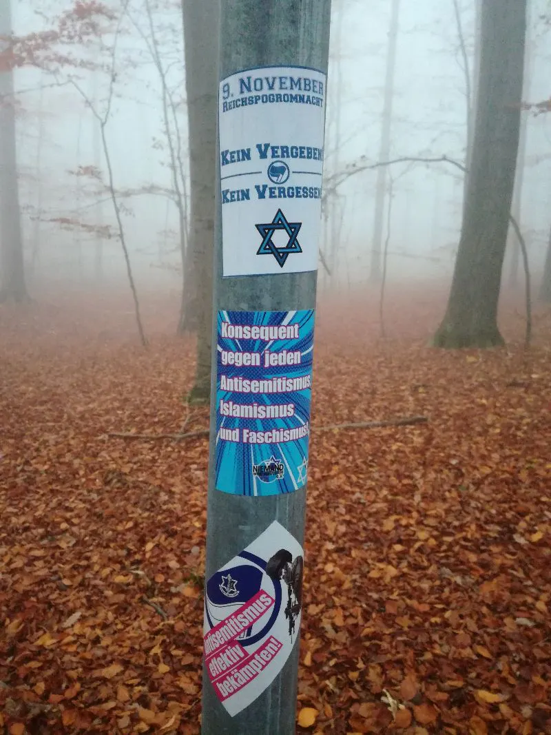 Wanderung Kernberge und Wöllmisse: Aufkleber gegen Antisemitismus und Islamismus an Pfahl vor vernebeltem Wald