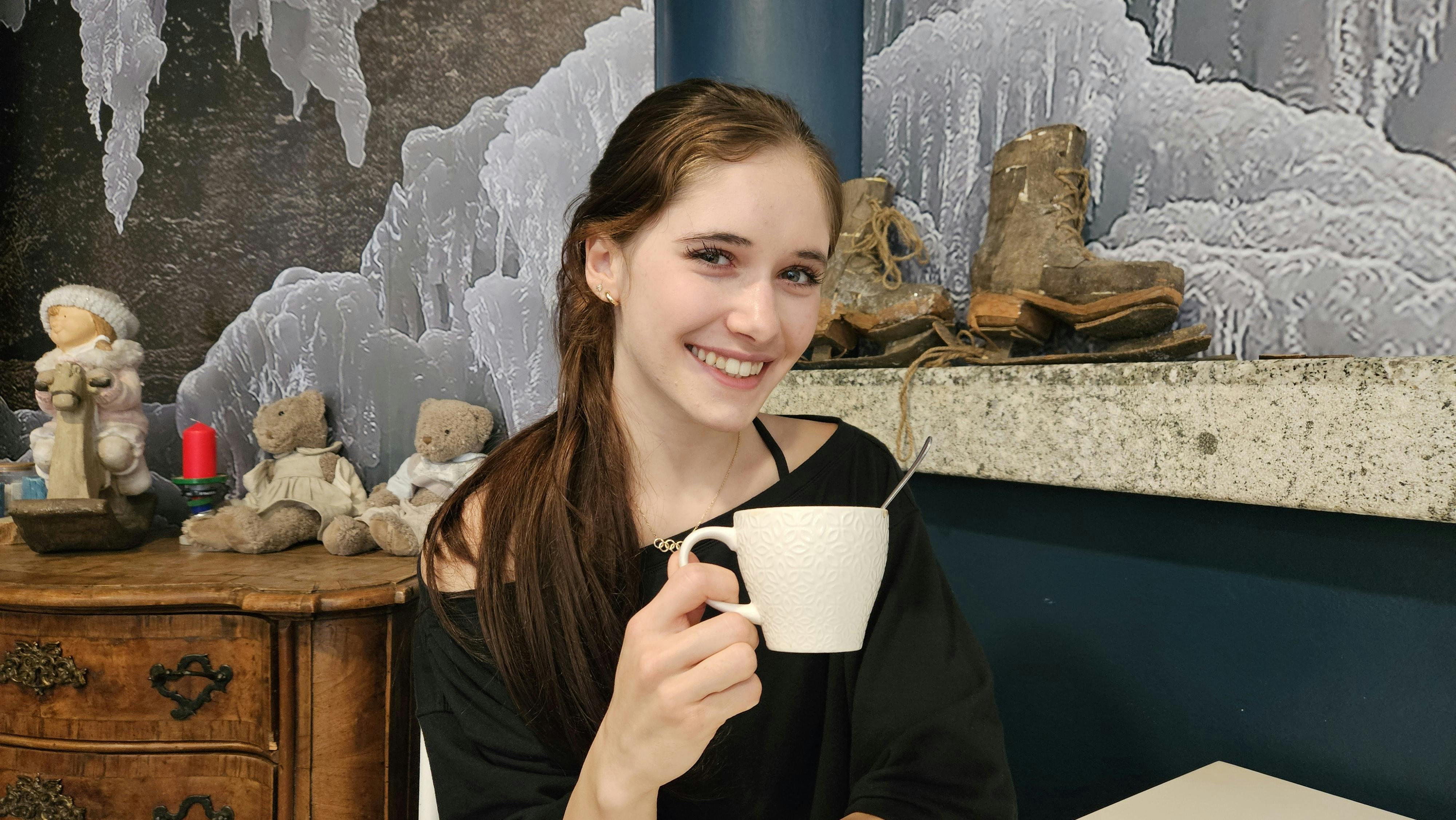 Isabeau Levito with a cup of cappuccino in the ice rink cafe