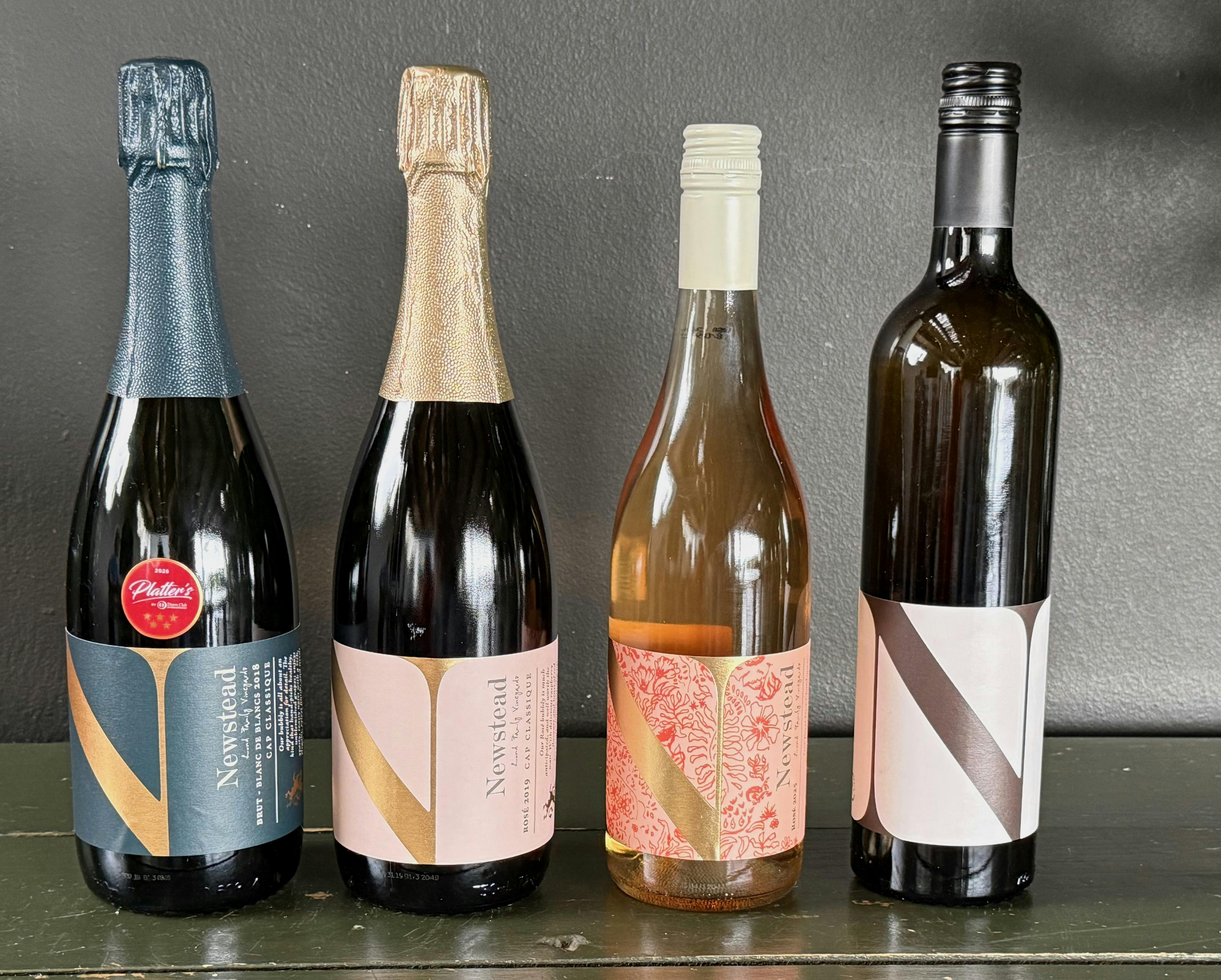 Vier Sekt- und Weinflaschen stehen auf einem Tisch