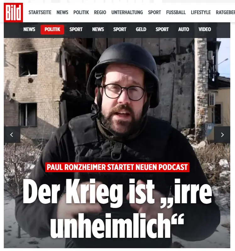 Screenshot bild.de, Paul Ronzheimer in Schutzkleidung vor einem offenbar zerbomten Haus, dazu die Schlagzeilen: 
PAUL RONZHEIMER STARTET NEUEN PODCAST. Der Krieg ist „irre unheimlich“.