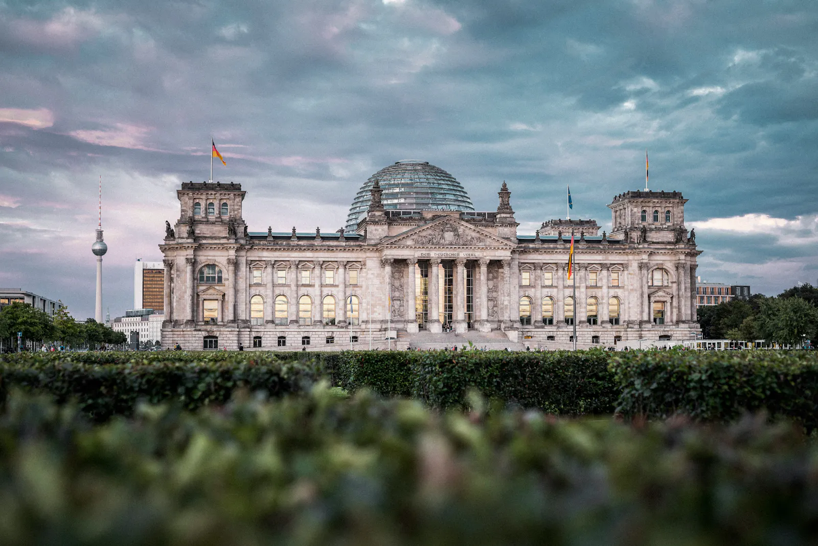 Bild von Hoch3fotografie des Deutschen Bundestags. Im Hintergrund ist ein wolkenbehangener Himmel zu sehen.