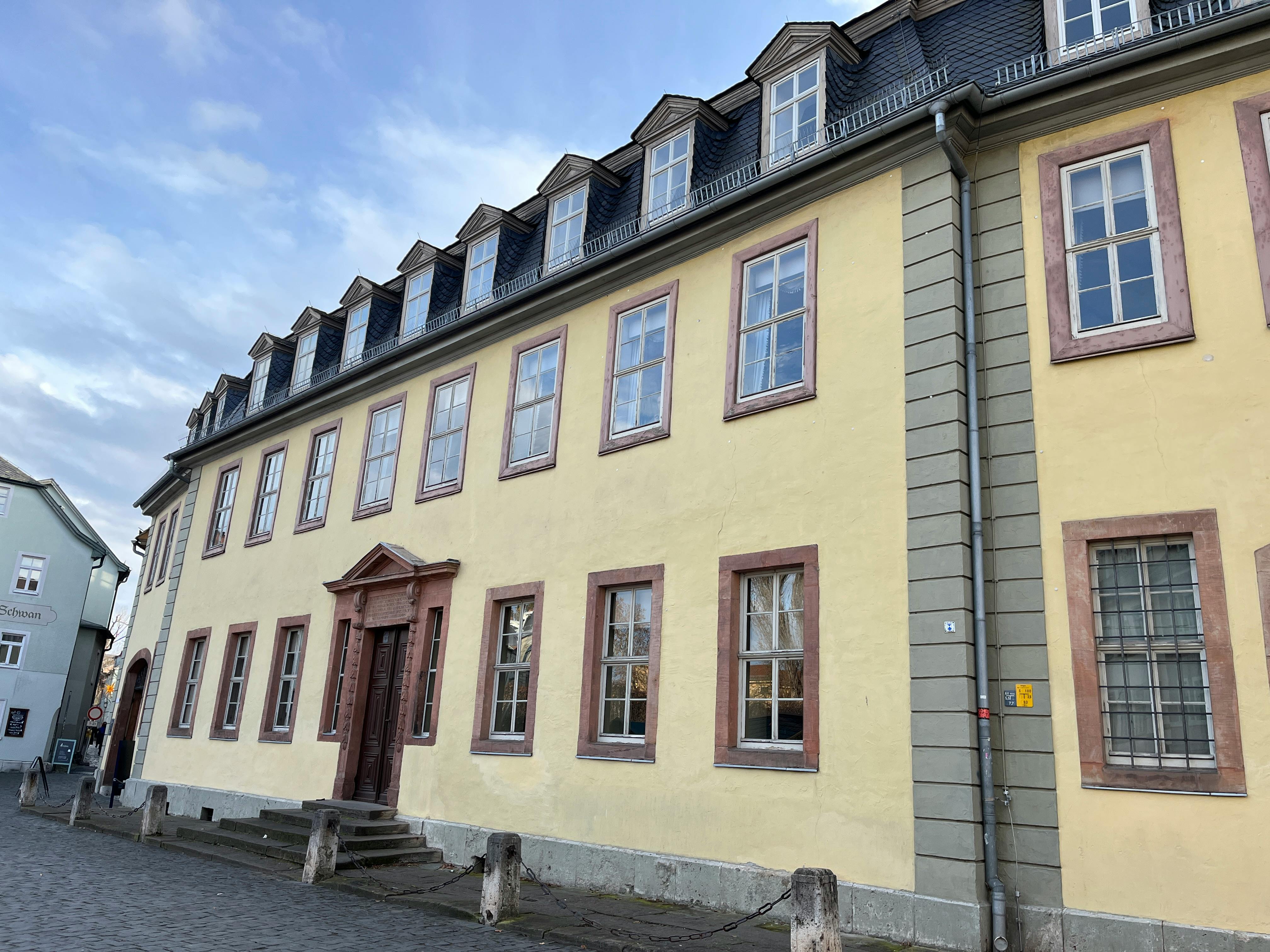 Außenansicht eines gelbgestrichenen dreistöckigen Hauses.