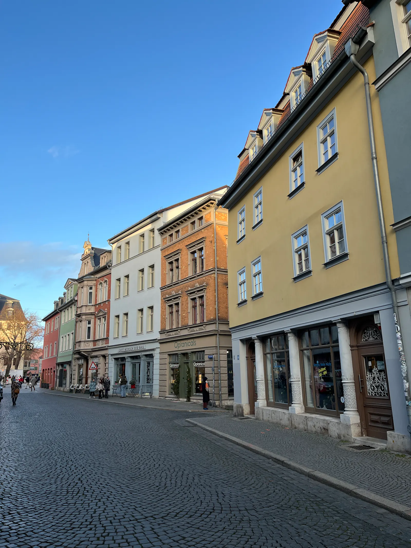 Straßenzug der Weimarer Altstadt. Schöne alte Häuser in bunten Farben. Darüber klarer hellblauer Winterhimmel.