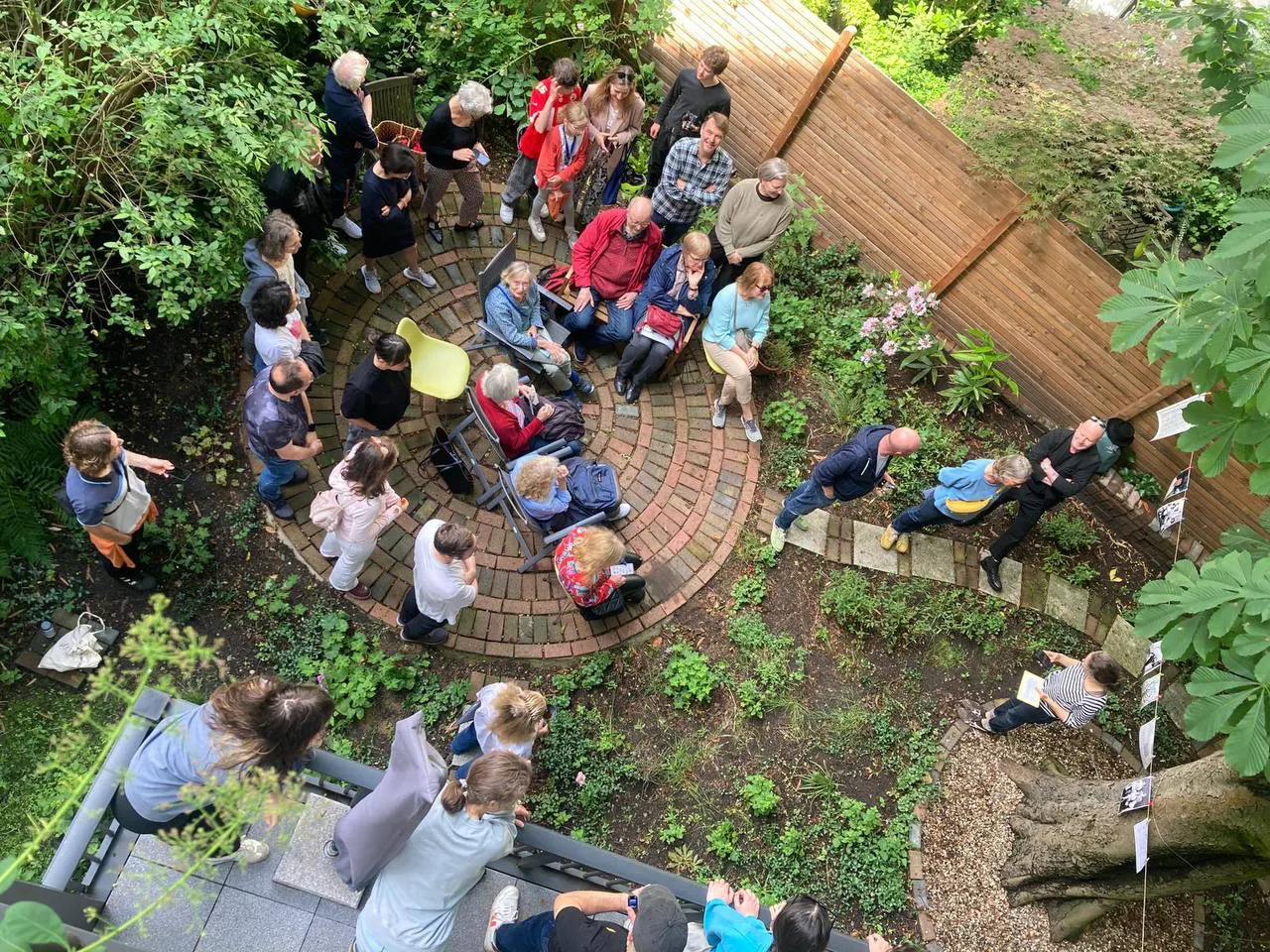 Menschen stehen in einem Garten zusammen. Foto: Sylvia Doria