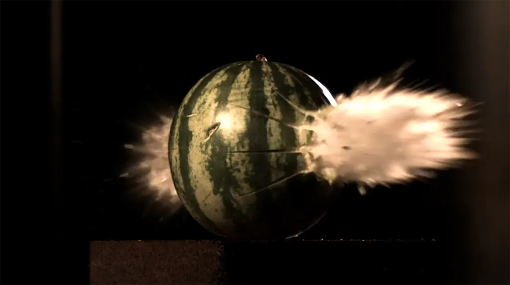 Eine Wassermelone wird von einem Projektil durchschlagen.