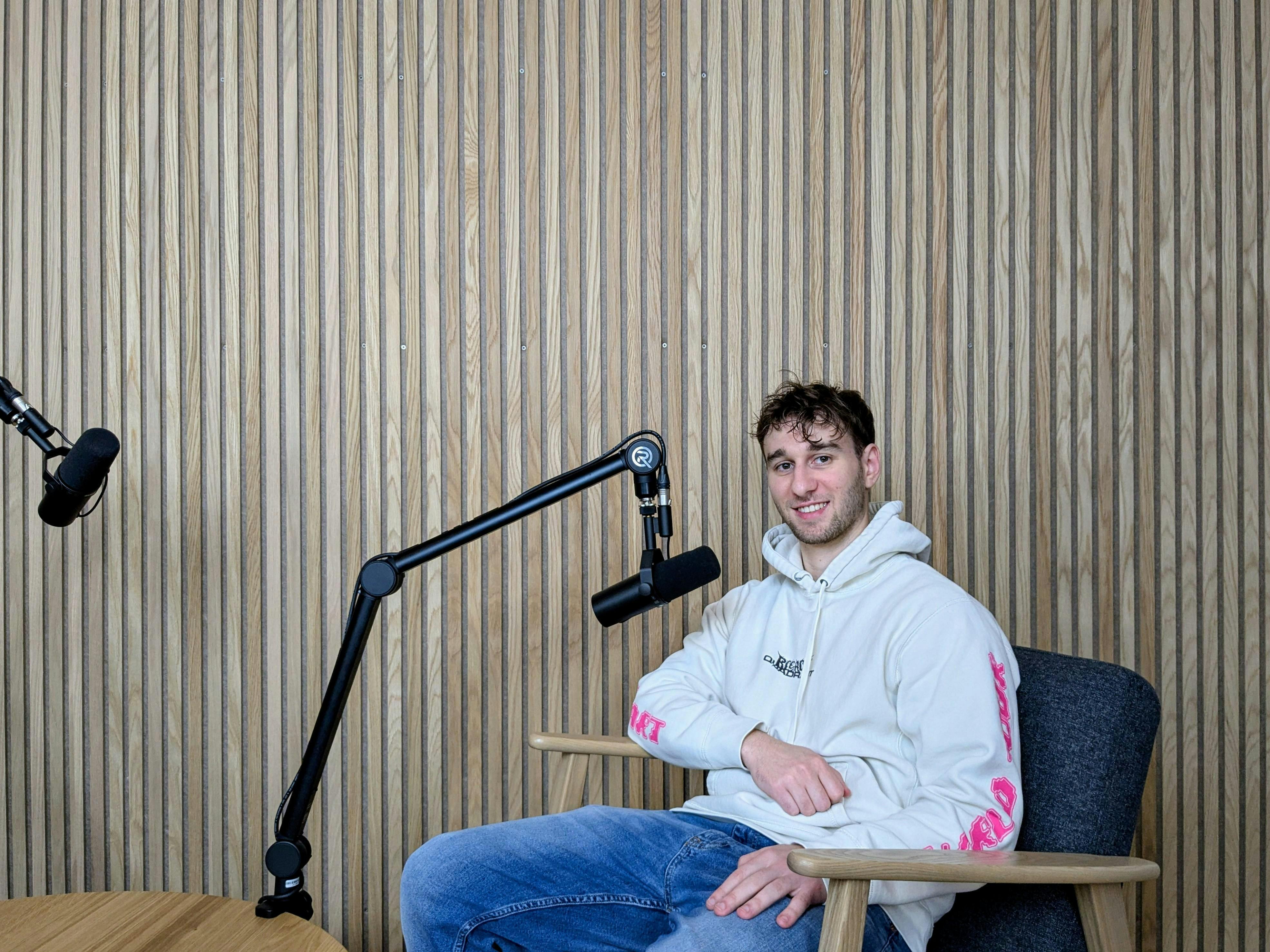 Niklas sitzt im Videostudio. Er und Maja freuen sich auf eure Anfragen!