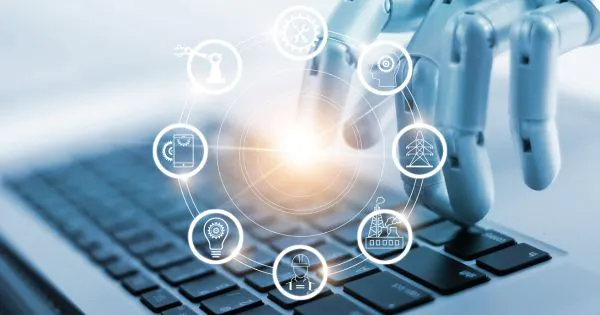 Eine Roboterhand, die auf Künstliche Intelligenz hinweist, tippt auf einer Computer-Tastatur / Bild: Canva