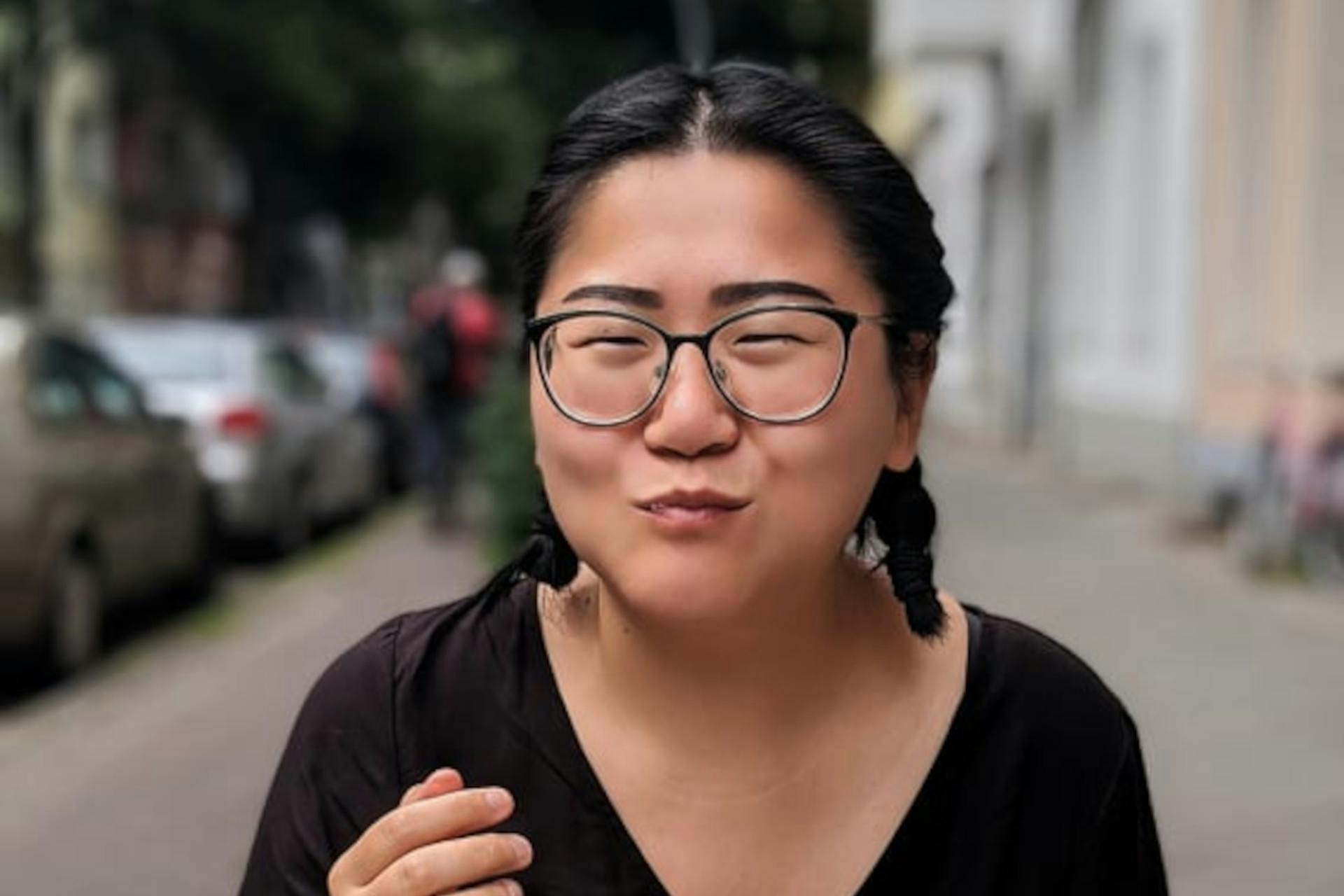 Sissi Chen im schwarzen Oberteil isst und macht ein zufriedenes Gesicht.