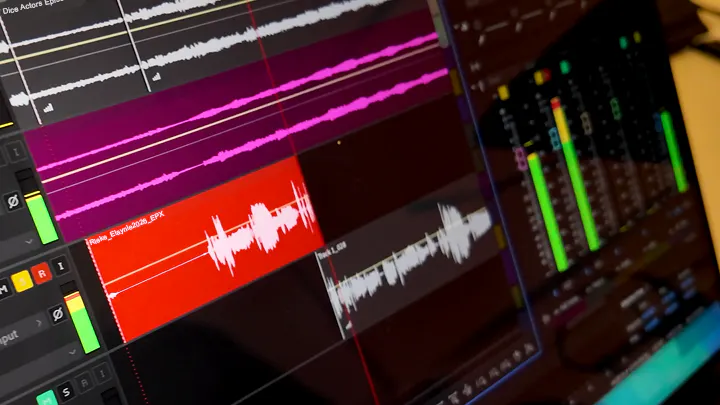 Nahaufnahme eines Computerbildschirms mit Audio-Editing-Software, auf dem mehrere farbige Tonspuren und Wellenformen sowie Pegelanzeigen zu sehen sind.