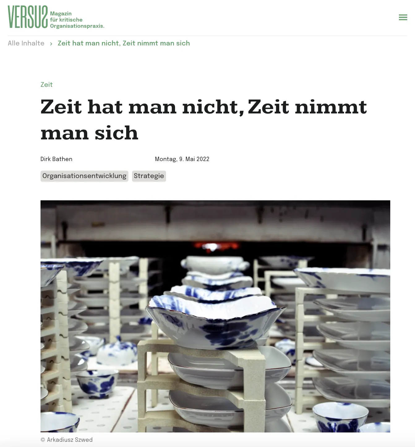Screenshot eines Artikels auf der Website des Magazins âVERSUS â Magazin fĂŒr kritische Organisationspraxisâ. Der Artikel trĂ€gt den Titel âZeit hat man nicht, Zeit nimmt man sichâ von Dirk Bathen, veröffentlicht am 9. Mai 2022. Unter dem Titel ist ein Bild von gestapeltem Porzellan in einem Brennofen zu sehen.