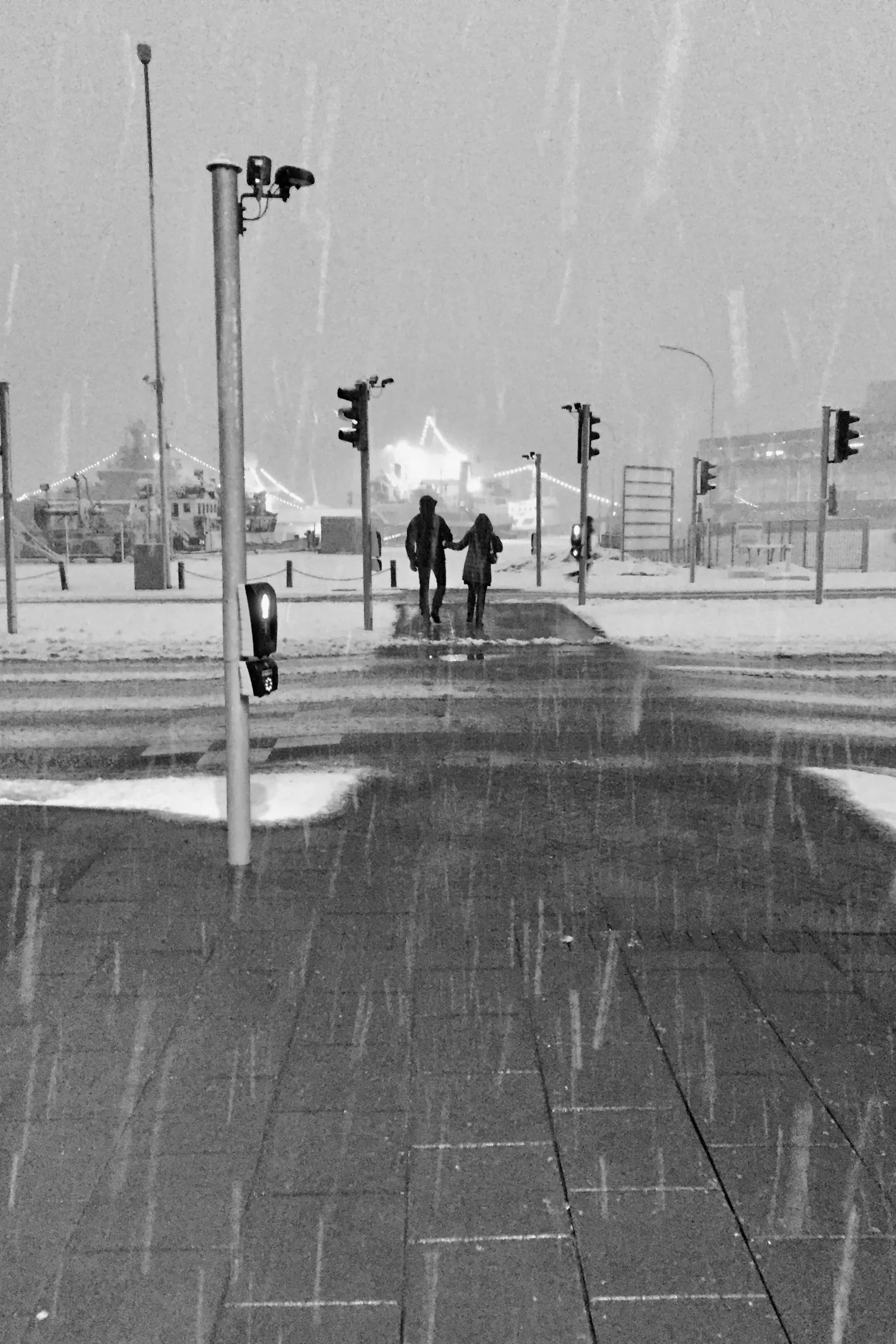 Two people walk together through snowy downtown Reykjavík