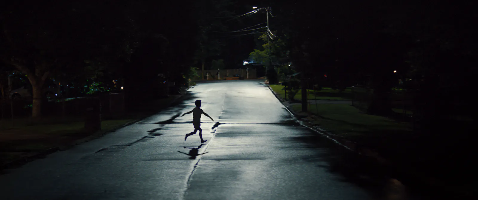 Eines der Kinder, die verschwinden im Film WEAPONS läuft wie als würde es Fliegen wollen über eine nächtliche Straße