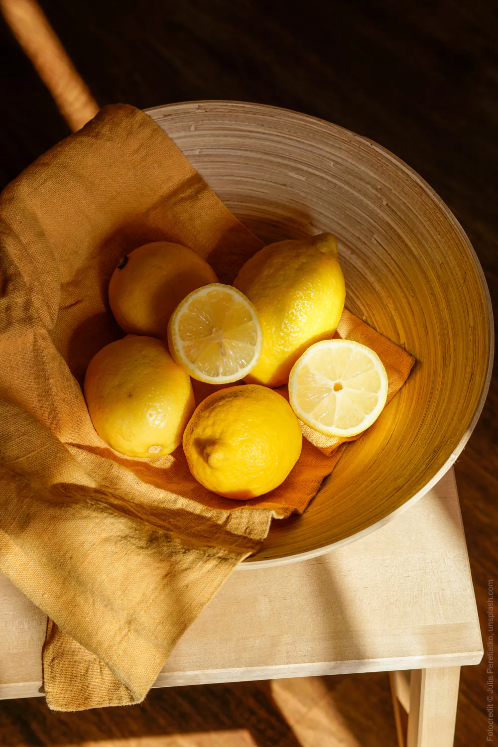Zitronen in Holzschale auf Holzstuhl