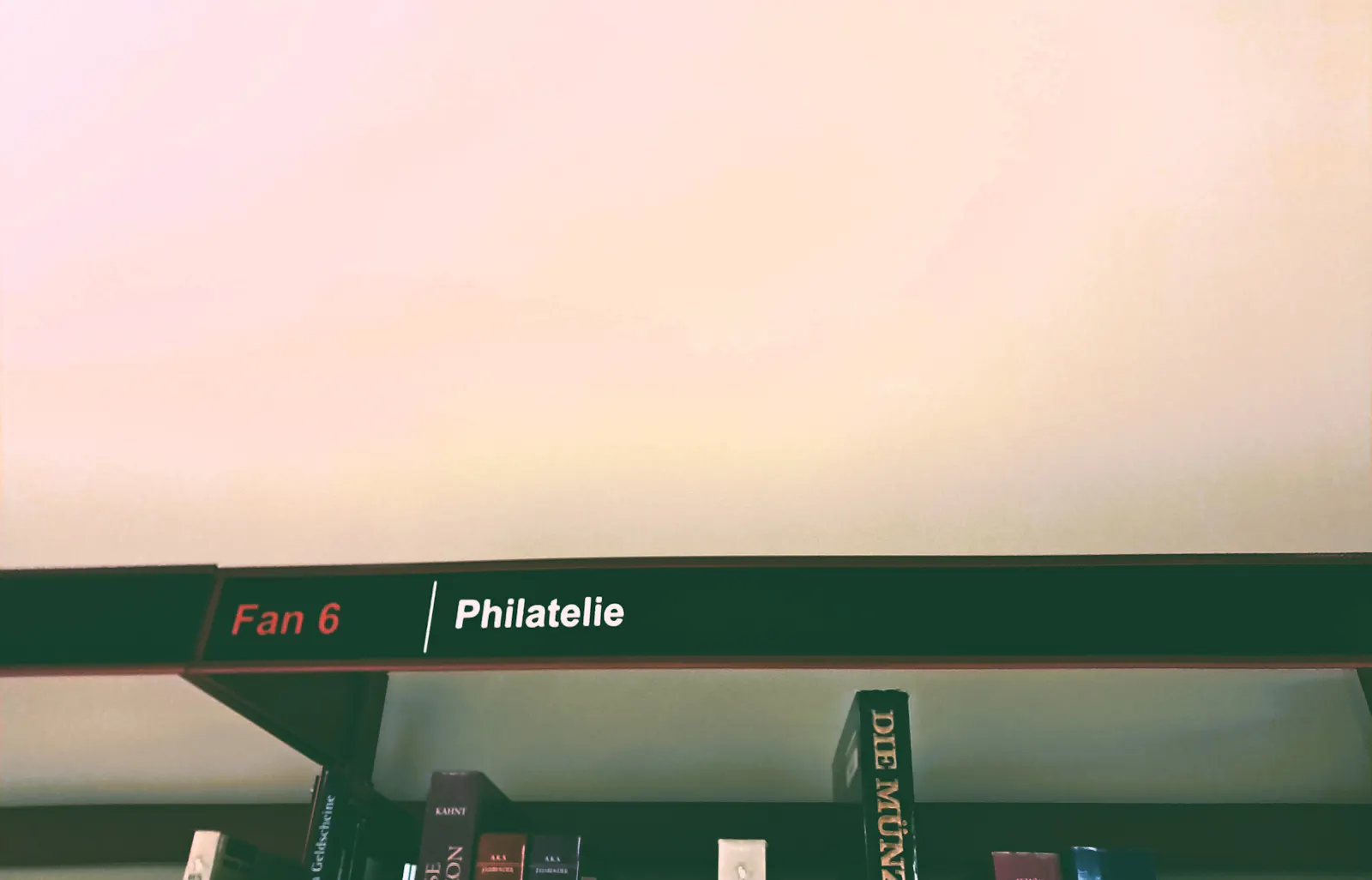 Ein Bibliotheksregal. Überschrift: Philatelie.