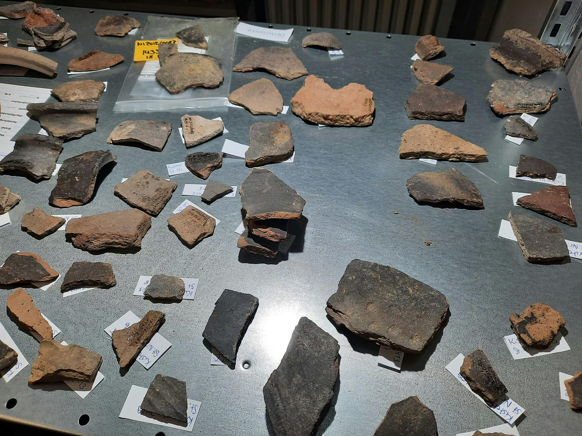 Auf einem Regalboden liegen Keramikscherben, unglasierte Wandscherben aus Duisburg Mercatorquartier. (Foto: Karina Schnakenberg)