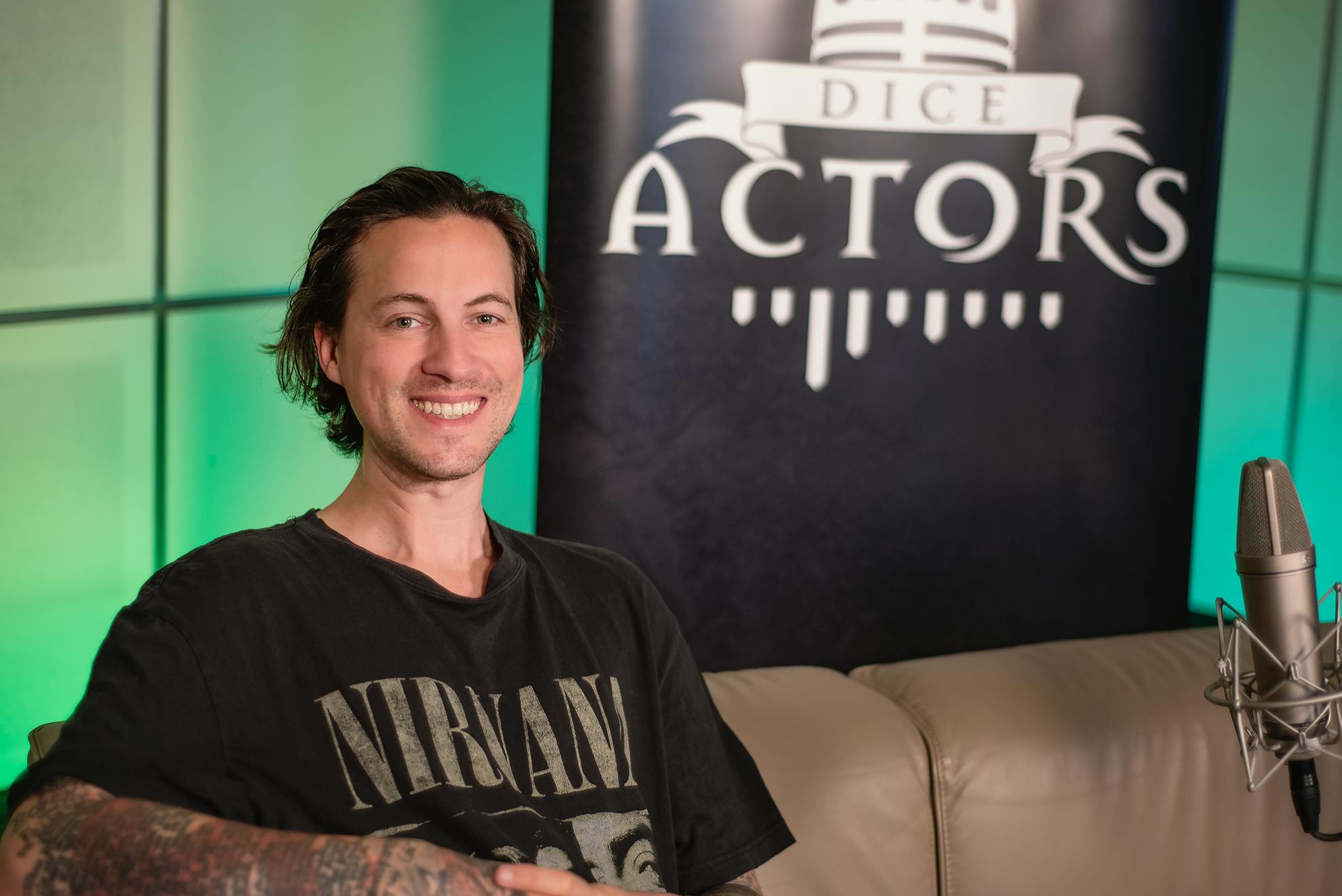 Patrick Roche, der auf dem Sofa sitzt und in die Kamera grinst.