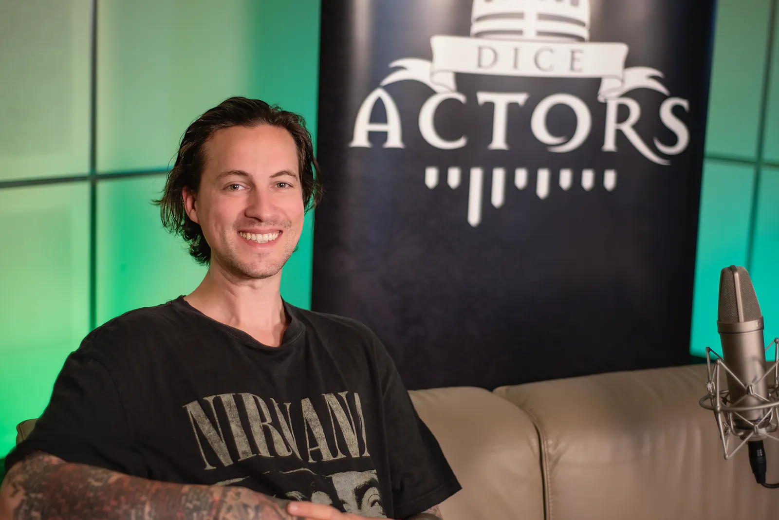 Patrick Roche, der auf dem Sofa sitzt und in die Kamera grinst.