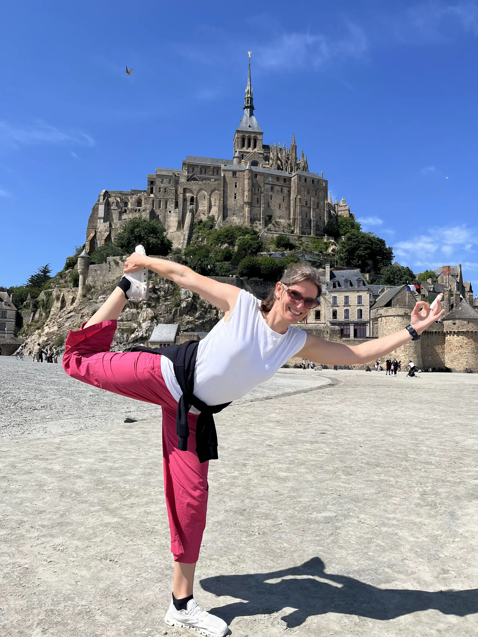 Yogalehrerin Anke Hermeling in der Yogahaltung "Der Tänzer" vor dem Mont Saint Michel