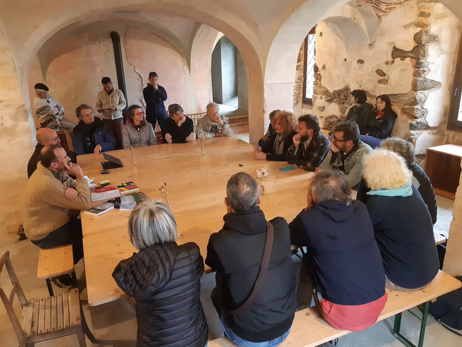 Locale della Trappa di Sordevolo con tavoli e panche da bierreria e le persone sedute intorno che discutono di Imparare Facendo, Riparare il mondo dalla Z