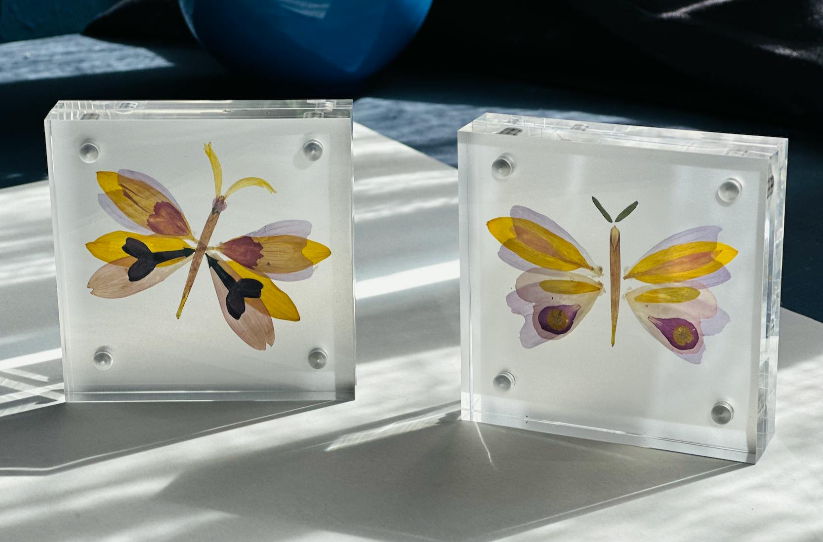 Flatternde Blütenschmetterlinge hinter Glas von Studio FLOR am 11. April 2026 auf dem ETAK-Markt in der East Side Mall in Berlin im Rahmen der Europäischen Tage des Kunsthandwerks