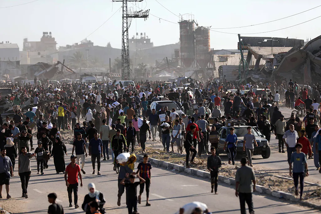 Tausende Menschen auf der Hauptstraße des Gazastreifens, viele tragen Mehlsäcke.