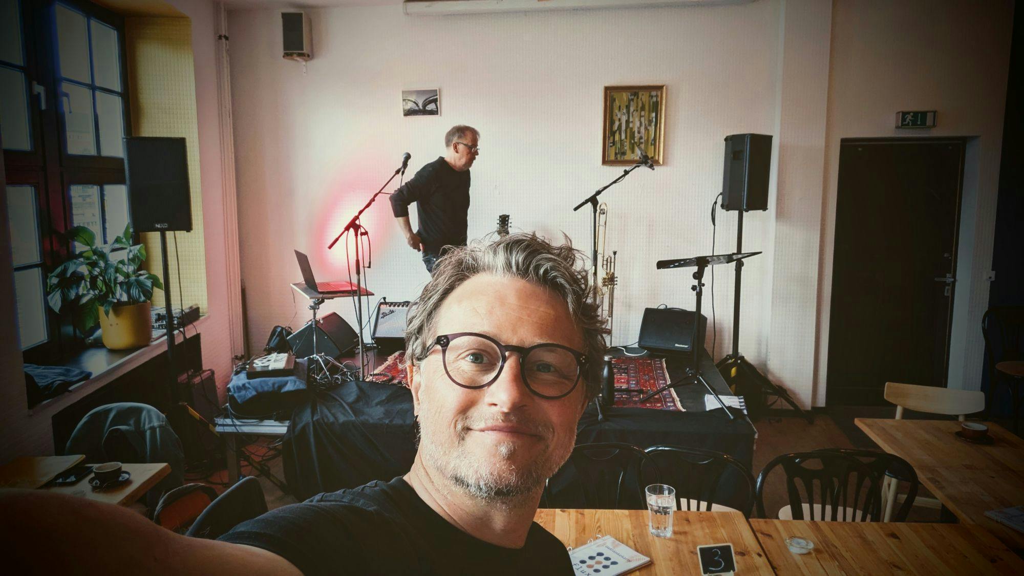 Ein Selfie von mir. Im Hintergrund baut mein Freund Martin die Technik für einen anstehenden Auftritt auf.