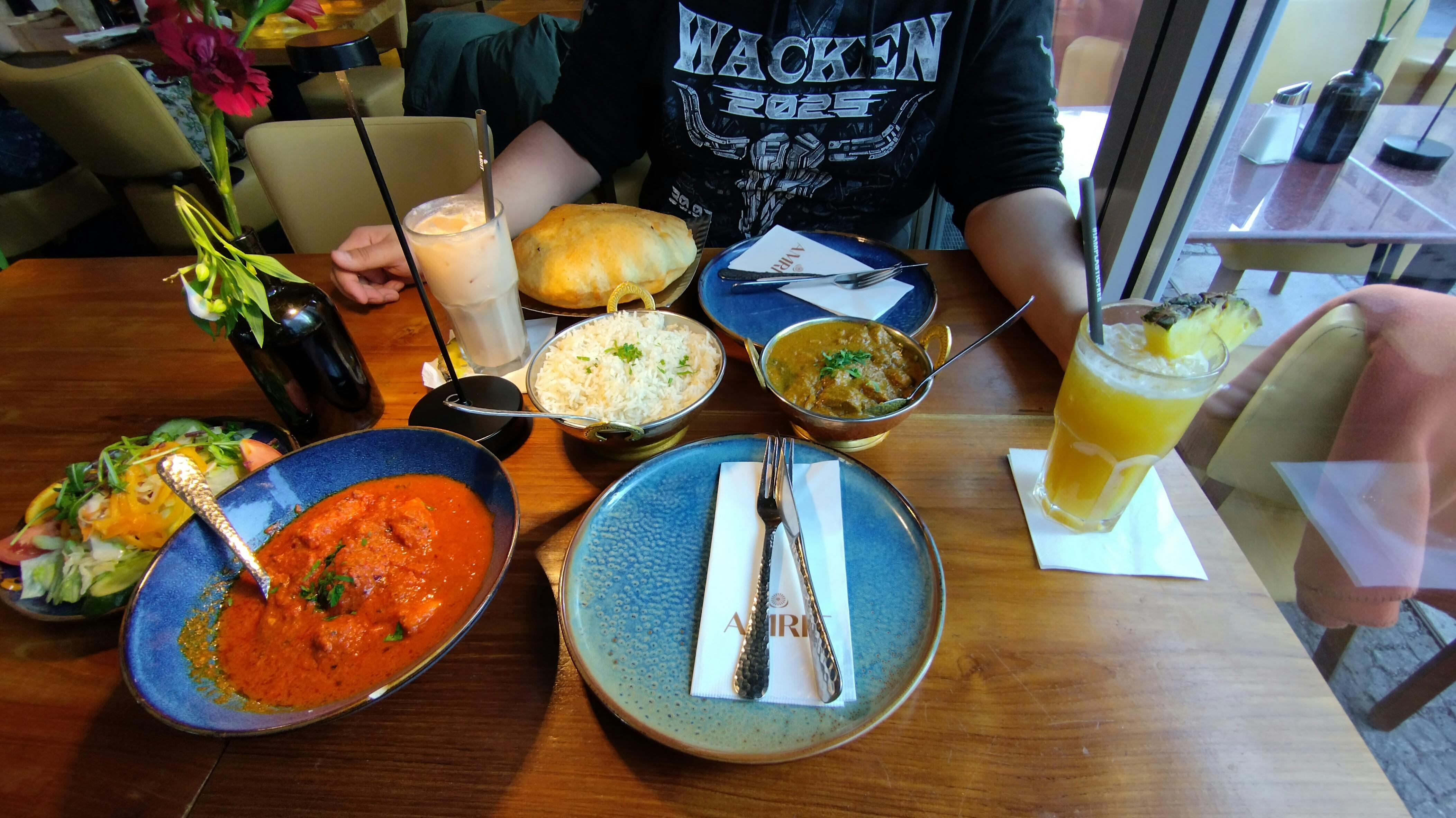 Foto von zwei Cocktails und einer Auswahl indischem Essen