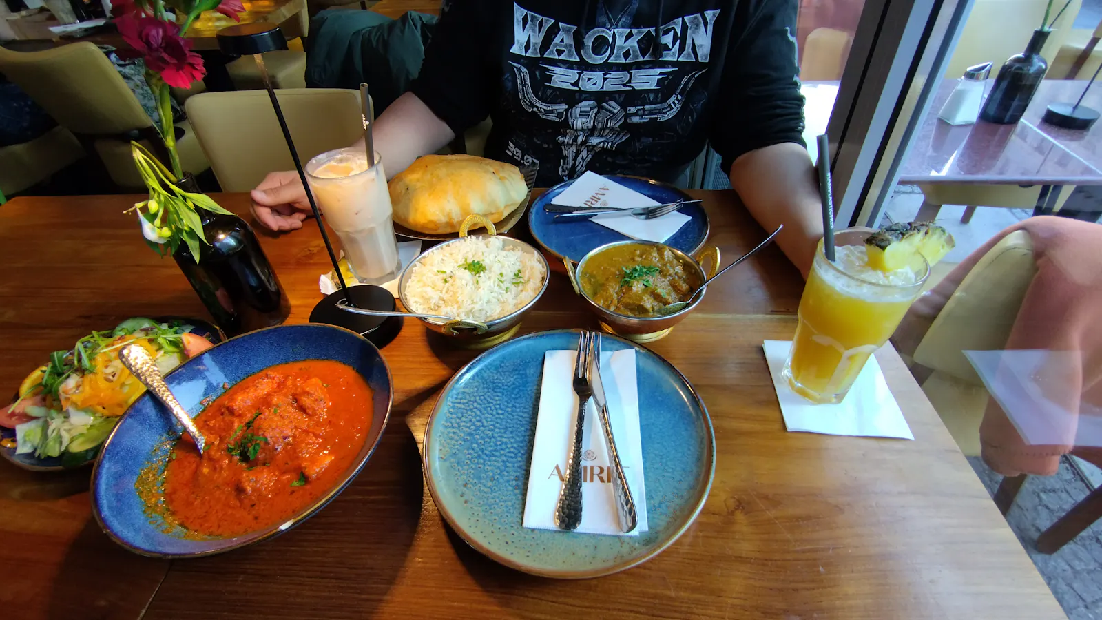 Foto von zwei Cocktails und einer Auswahl indischem Essen