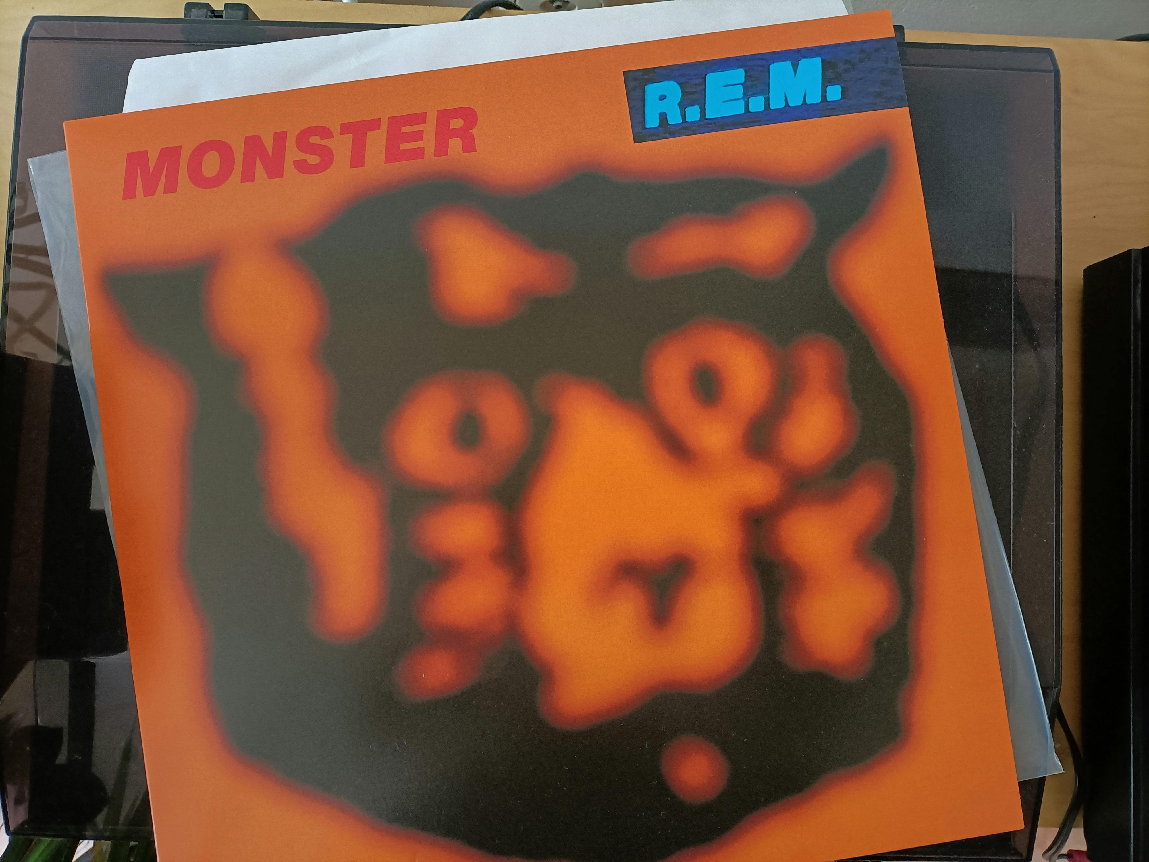 cover of an LP, REM "Monster"
orange, with a black, blurry head of a bear