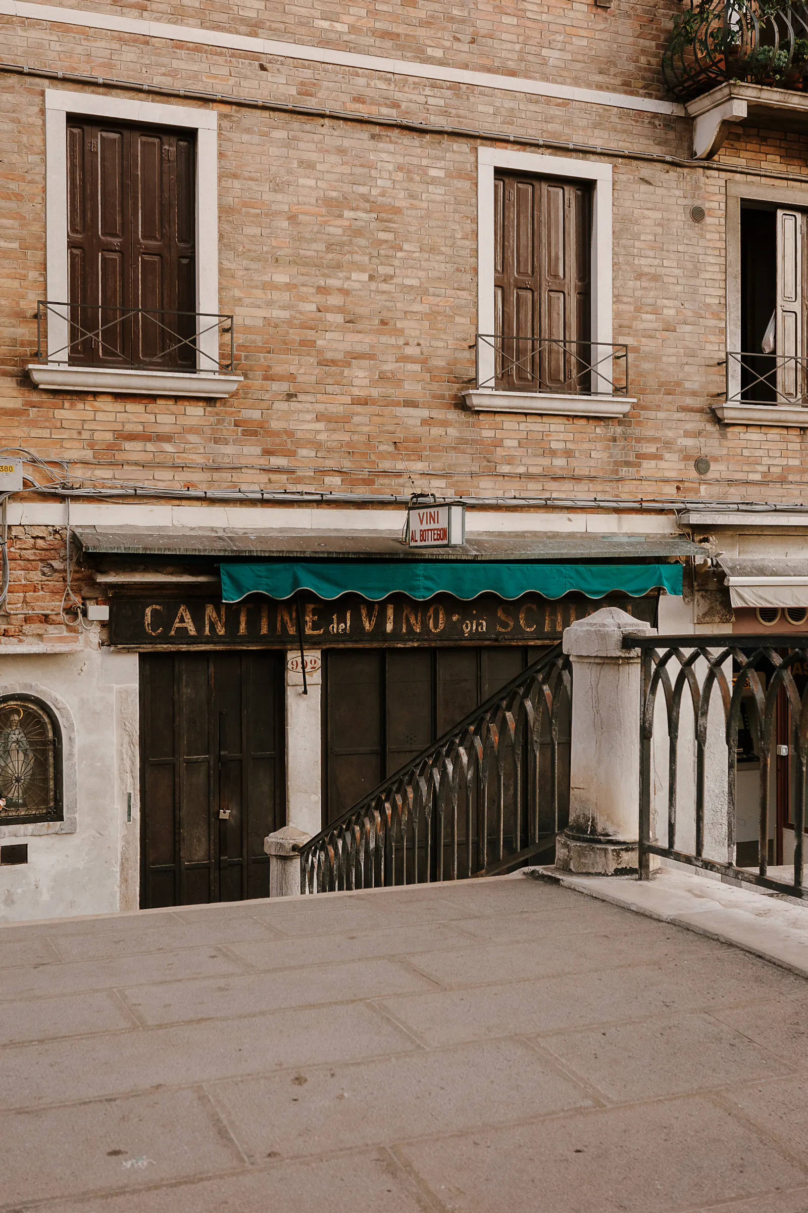 Der Blick von einer der Brücken in Venedig auf eine Weinbar. Sie ist mit dunklen Holzläden verschlossen