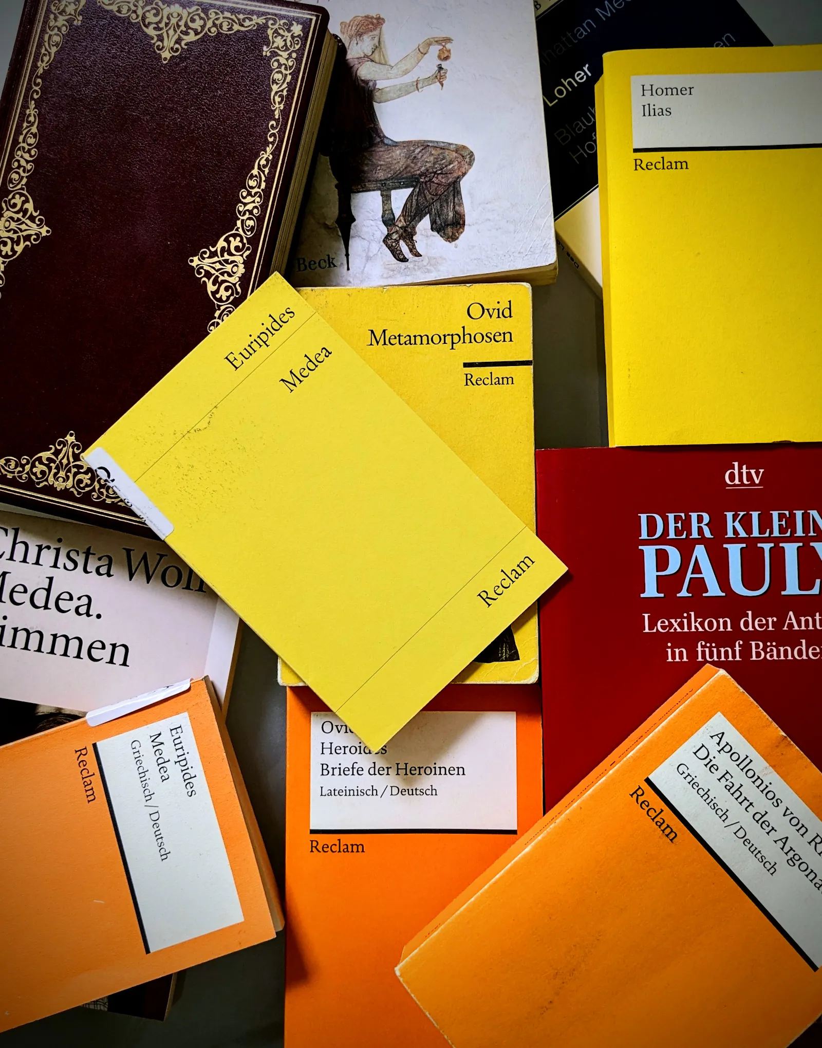 Ein Foto von einem Haufen Bücher, mit meinem Smartphone aufgenommen. Es sind Bücher, die ich zur Recherche zum Thema Medea nutze. Vorne auf: Euripides - Medea. Auch dabei: Ovids Metamorphosen, Die Fahrt der Argonauten von Apollonius von Rhodos, Ovids "Heroides - Briefe der Heldinnen", Der Kleine Pauly, Will Durants Kulturgeschichte der Menschheit, Homers Ilias, Elke Hartmanns "Frauen in der Antike" uvm.
