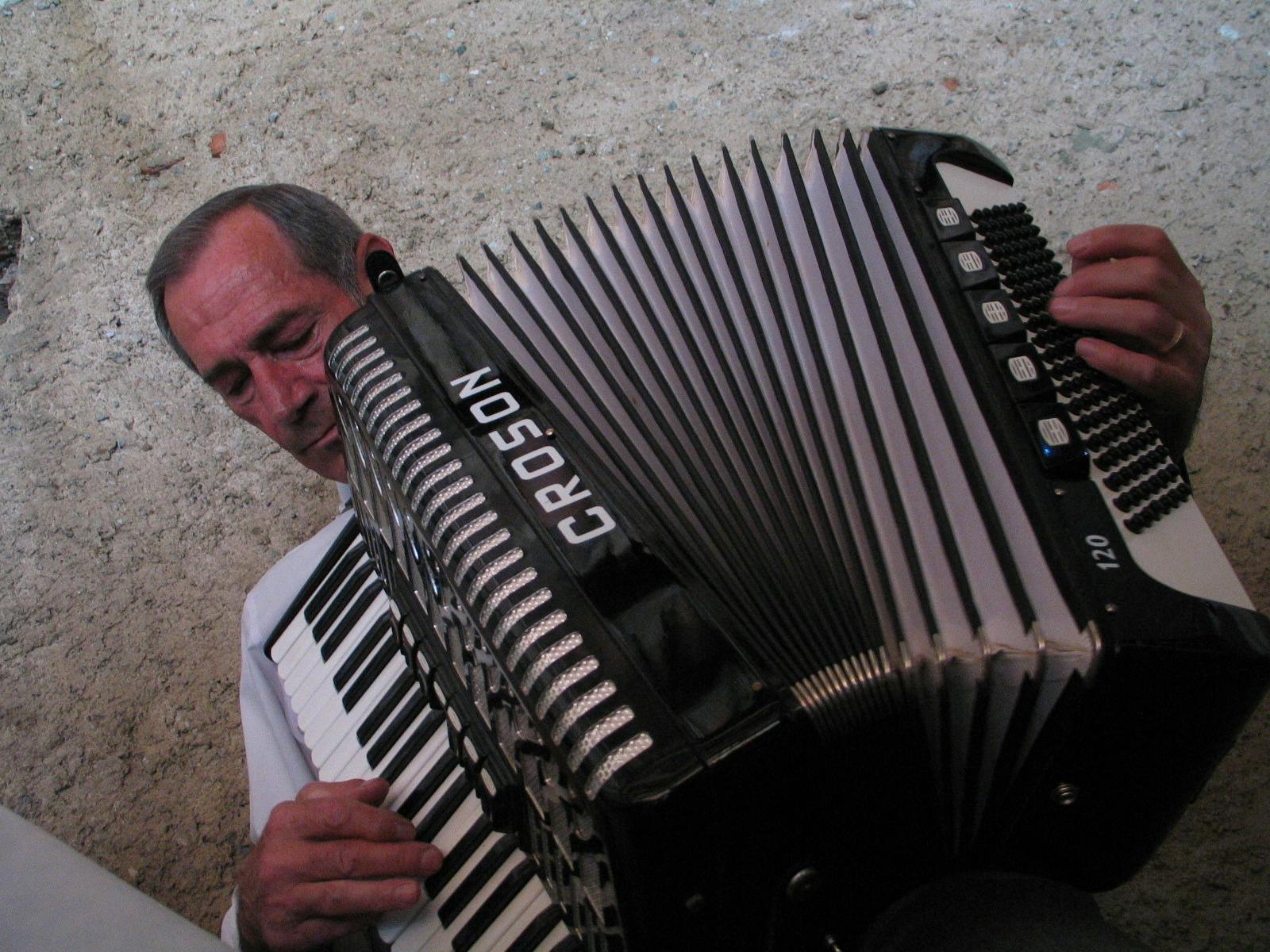 Uomo con una fisarmonica sullo sfondo un vecchio intonaco in calce. Nota bene la fisarmonica era dello sposo