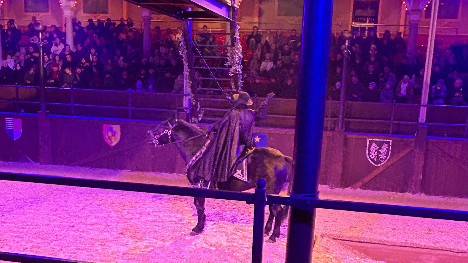 Auf einem schwarzen Pferd sitzt ein Reiter mit schwarzem Hut und Umhang