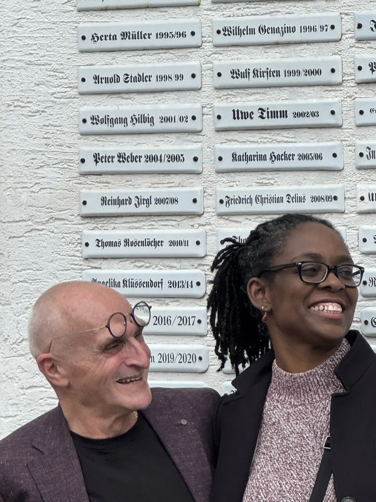 José Oliver und Sharon Dodua Otoo stehen lächelnd vor dem Stadtschreiberhaus in Bergen.